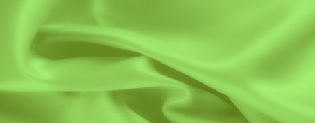 Blur of smooth green fabric in gentle folds, displaying a soft, silky texture with delicate lighting. The image highlights the fabric's fluidity, creating a serene and luxurious atmosphere.の写真素材