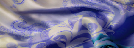 Blur, a close-up of blue fabric with soft floral designs in green and cream tones. The intricate...