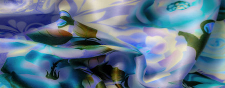 Blur, a detailed shot of fabric showing a beautiful floral pattern in shades of blue, green, and cream. The soft, smooth folds and subtle texture bring eleganceの写真素材
