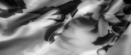Blur of delicate rose and leaf details on a smooth, grayscale fabric. The satin-like texture adds depth and sophistication to this classic, black and white floral design.の写真素材