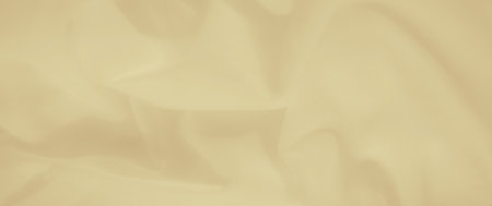 Blurred yellow fabric with flowing folds and smooth textures. The bright and vibrant color brings a lively yet cozy feel, suitable for backgrounds and textile designs.の写真素材