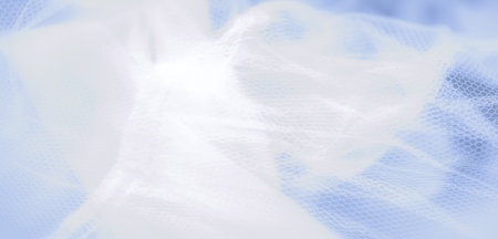 Blur of delicate light blue fabric, featuring smooth, flowing folds and a tranquil pastel hue, ideal for backgrounds and evoking a sense of softness and calmの写真素材