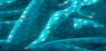 Blurred close-up of delicate light blue fabric with white star patterns, elegantly draped, creating...