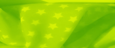 Blur of a bright green fabric with softly glowing stars scattered throughout. The smooth texture and...