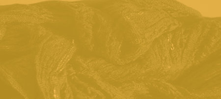 Blurred close-up of soft yellow fabric with delicate, almost invisible woven patterns, creating an organic, calm texture for a subtle decorative background.の写真素材