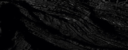 Blur: Black fabric with a finely woven texture captures the light in a soft, scattered way, creating a shadowed depth across the material's intricate folds and layered patterns.の写真素材