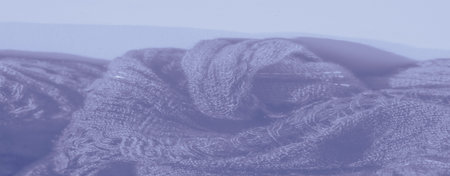 Blur close-up of fabric with wavy textures and a shimmering effect. Soft blue tones and delicate weave create a calm, soothing atmosphere, ideal for backgrounds.の写真素材
