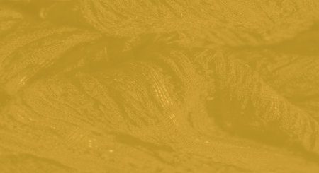 Blur of yellow fabric showing a subtle, flowing texture with light play across its soft surface, providing an abstract yet inviting background for creative useの写真素材