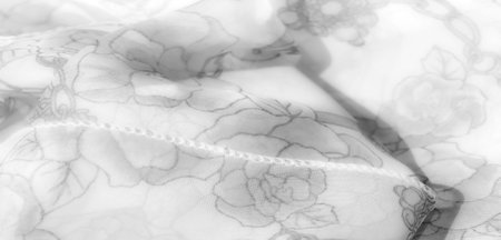 Blur effect captures the soft, intertwining floral and abstract chain patterns on this grayscale...