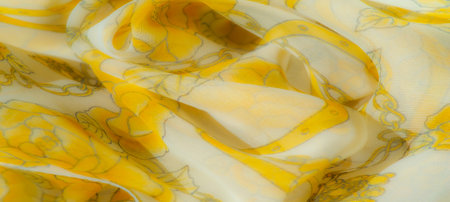 Blur of a sheer yellow fabric with soft floral patterns, gracefully layered and flowing, showing intricate outlines and delicate flower details for an elegant, airy texture.の写真素材