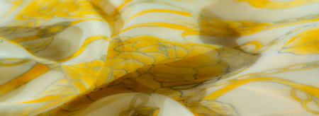 Blur of soft yellow floral fabric, showing intricate floral elements and gentle folds that convey an airy and delicate aesthetic, full of warmth and elegance.の写真素材