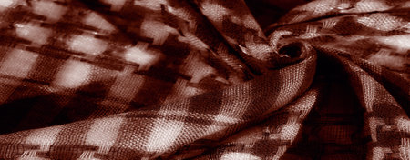 Blur of rich sepia fabric in a woven design, showing light textures and a vintage-inspired pattern. Depth and soft contrasts emphasize the intricate woven structure of the textile.の写真素材