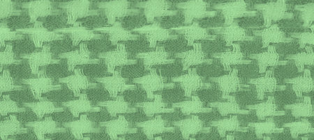 Blur of green fabric with woven plaid texture, highlighting the soft folds and intricate patterns....