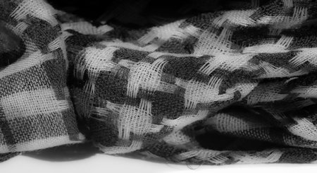 Blur of a soft, monochrome textile featuring interwoven black and white patterns, creating a high-detail texture. The smooth folds enhance the fabric's elegant and contemporary look,の写真素材