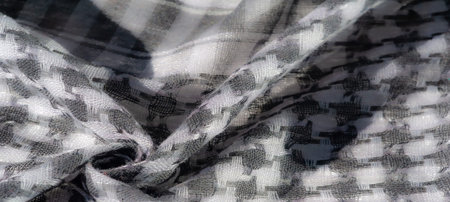 Blurred grayscale fabric with layered textures and intricate woven details. The close-up highlights...