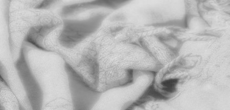Blur. An elegant close-up of smooth white fabric with intricate textures, highlighted by gentle...