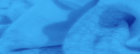 Blur of blue fabric showing a gentle, flowing texture. The fabric's folds and soft material create a soothing, dreamy atmosphere, making it ideal for background designs or artistic projects.の写真素材