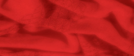 Blurred image of smooth red fabric with soft folds, creating a luxurious and warm look. Shadows play...