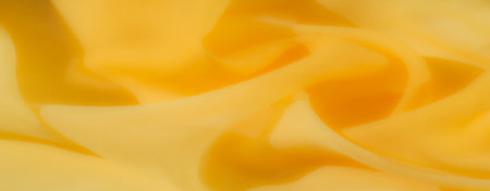 Blur - A beautifully folded yellow fabric with soft, swirling curves that convey warmth and softness. The delicate texture and vibrant yellow shade make it perfect for abstract backgroundsの写真素材