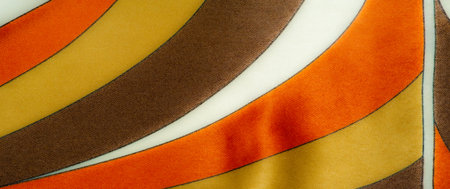 Blur of bright yellow, orange, and brown striped fabric with soft folds, creating a luxurious...