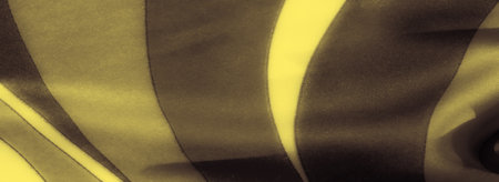 Blur of golden and deep dark tones flow in soft, folded fabric, creating a modern yet elegant abstract pattern. Light highlights provide depth and texture to the fabric's gentle curves.の写真素材