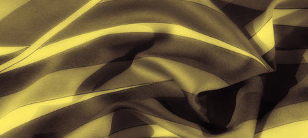 Blur of a yellow fabric with dark, sweeping patterns creates a striking abstract effect, blending soft texture with vibrant hues, perfect for modern design elements.の写真素材
