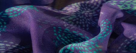 Blur A soft purple fabric featuring intricate turquoise patterns artistically folded to highlight the play of light and texture The colors blend seamlessly giving the fabric a dynamic and luxurious loの写真素材