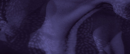 Blur, deep indigo fabric with intricate swirling patterns creates a mesmerizing, abstract texture. The delicate folds and soft fabric structure enhance the visual appeal.の写真素材