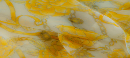 Blur A beautiful, sheer yellow fabric adorned with intricate floral patterns, displaying flowing folds in a close-up. The transparent texture adds warmth and elegance to the floral design.の写真素材