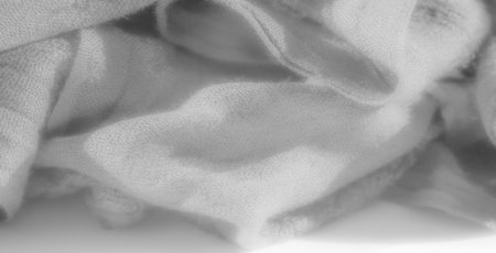 Blur brings out the layered textures of delicate white fabric, casting soft shadows within gentle...