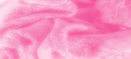 Blurred soft pink fabric with gentle creases and a flowing texture. The delicate light accents and smooth appearance make it perfect for backgrounds with a feminine, elegant touch.の写真素材