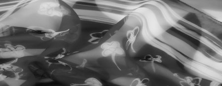 Blurred abstract fabric design in grayscale, featuring soft floral accents. The light interplay on the flowing fabric emphasizes its translucent, elegant texture.の写真素材