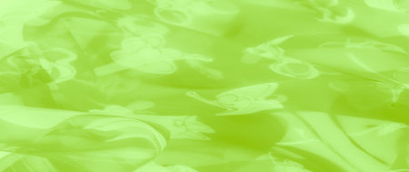 Blur of lime green fabric with an airy floral design and subtle stripes, offering a dynamic and refreshing visual appeal with its glossy, lightweight foldsの写真素材
