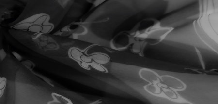 Blurred image showing monochrome floral patterns on lightweight fabric. The soft textures and flowing folds evoke elegance and artistic creativity.の写真素材