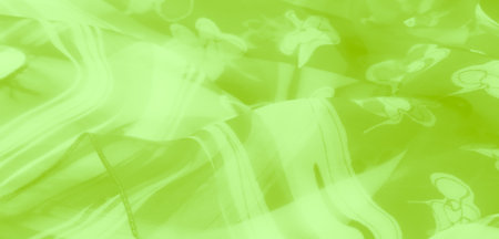 Blur Delicate lime green fabric with intricate floral patterns, creating a soft and flowing texture with subtle transparency. The material reflects light beautifully.の写真素材