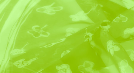 Blur. A stunning green fabric with a delicate floral pattern, showing a luminous surface and flowing folds, ideal for decorative and stylish textile designs.の写真素材