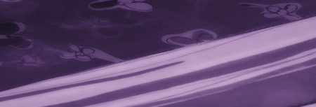 Blur of translucent purple fabric with floral prints and intricate striped patterns. Highlights smooth textures and a sophisticated, artistic design.の写真素材