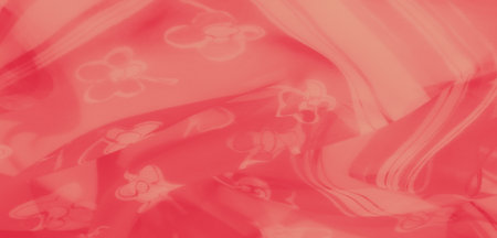 Blur of coral fabric with soft floral patterns, featuring layered sheer textures for a subtle yet sophisticated textile appearance.の写真素材