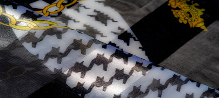 Blur of glossy black and white textile with intricate golden chain motifs. The luxurious folds and bold patterns exude an artistic and refined vibe.の写真素材