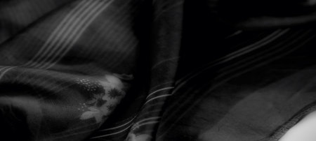 Blur. A soft draping of black fabric with thin white stripes creates a striking interplay of light...