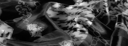 Blur - Fabric with houndstooth and chain patterns in grayscale, accentuated with a reflective finish and soft folds, creating a sophisticated modern design.の写真素材