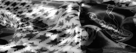 Blur of a fabric with alternating floral chain and geometric houndstooth motifs in grayscale,...