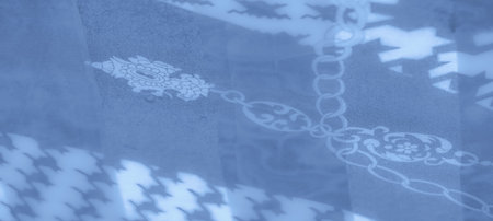 Blur: Smooth and flowing blue fabric adorned with chain patterns and abstract shapes, creating a...