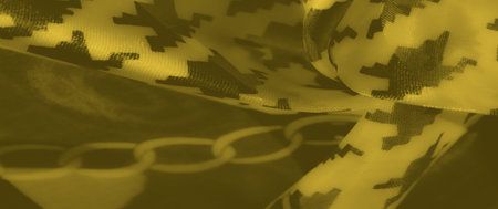A yellow fabric design featuring interwoven chain patterns and intricate shapes, offering a textured...