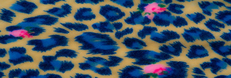 Blurred close-up of soft fabric showcasing vivid blue leopard-like patterns with pink floral accents...