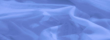 Blur of abstract blue fabric with soft textures and dynamic flowing shapes, combining elegance and simplicity for use in creative designs and calming backgroundsの写真素材