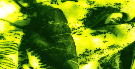 Blur of intricately folded green and black fabric showcasing bold abstract patterns and glowing streaks for a dynamic, high-contrast compositionの写真素材