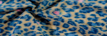 Blur abstract blue leopard print fabric layered over beige tones with soft pink floral accents,...