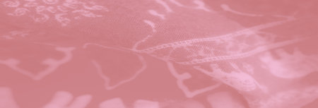 Blurred image of soft pink fabric with intricate elephant motifs, creating a delicate and artistic pattern. The folds add a touch of elegance and dimension to the design.の写真素材