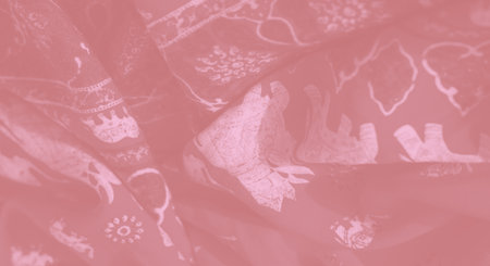 Blurred close-up of pink fabric with elegant floral and elephant motifs, swirling in smooth folds to highlight the material's intricate design and luxurious texture.の写真素材